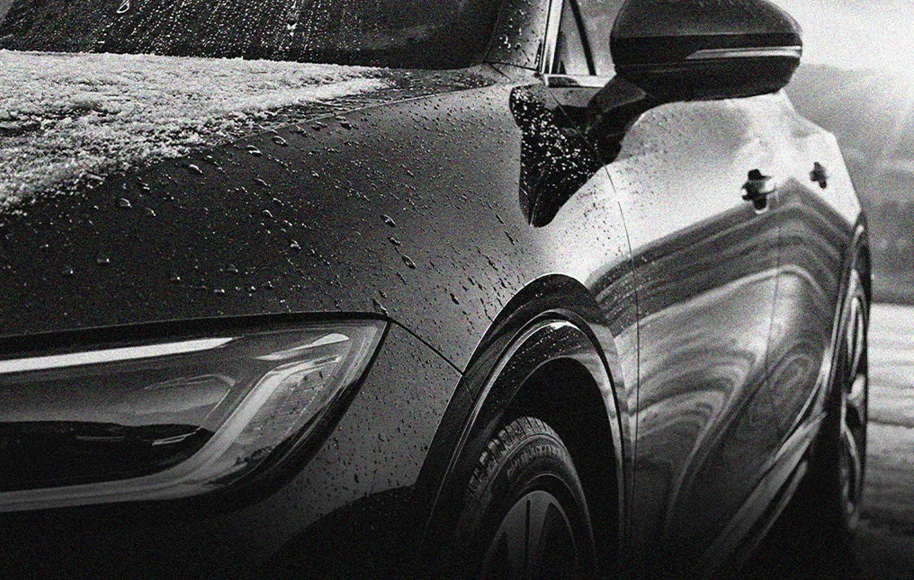 Water beads on a black vehicle protected by paint protection film