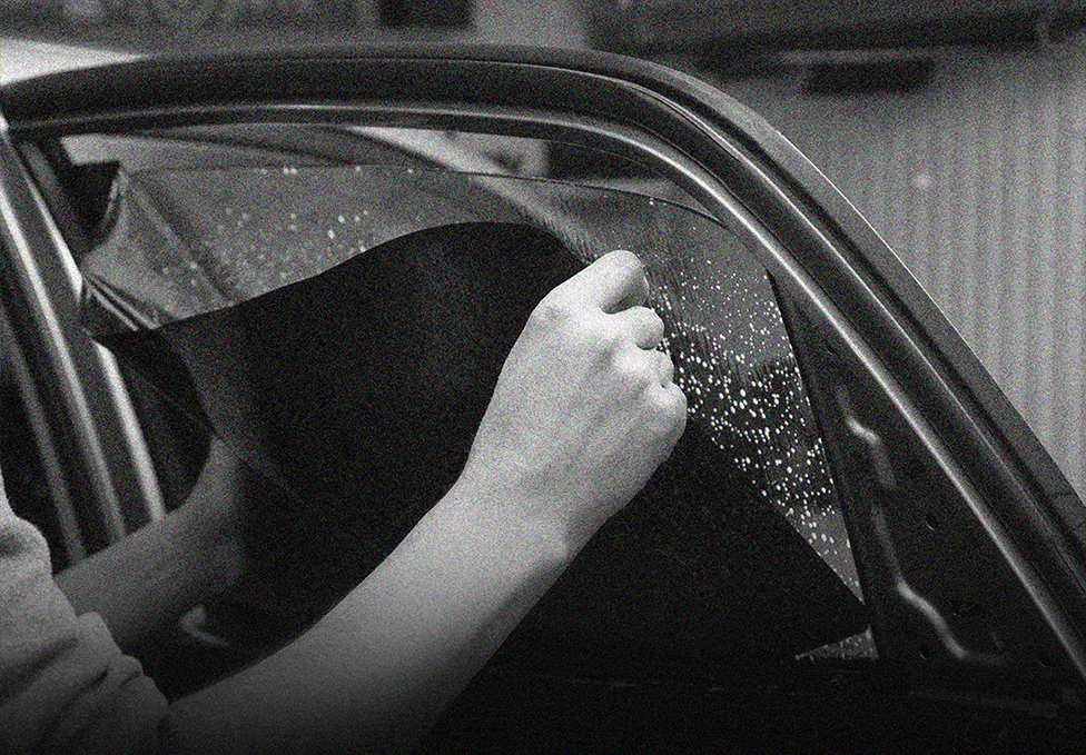 Installer positioning automotive window film on side glass